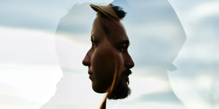 Double exposure: side profile of a man wearing a hat, blended with a cloudy sky backdrop.